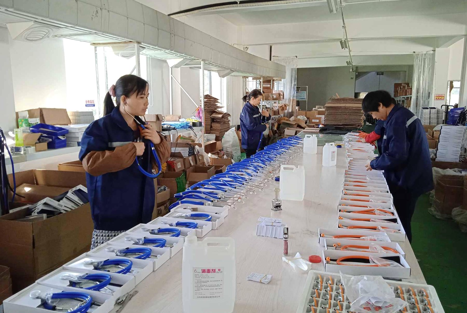 Technicians inspecting stainless steel medical instruments in a quality control workshop